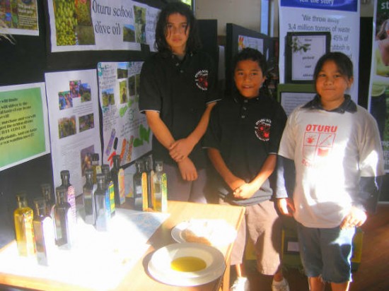 Isaac Cassidy Taylor, Kaweka Isaac-Kingi and Mere Howard offer tastings of the delicious olive oil produced from trees they tend at Oturu School.
